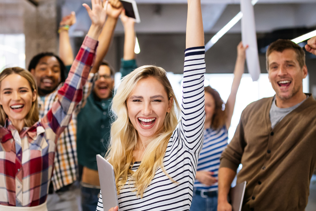A group of professionals celebrating success, representing values-aligned recruitment with the best AI-powered job boards for nonprofits.