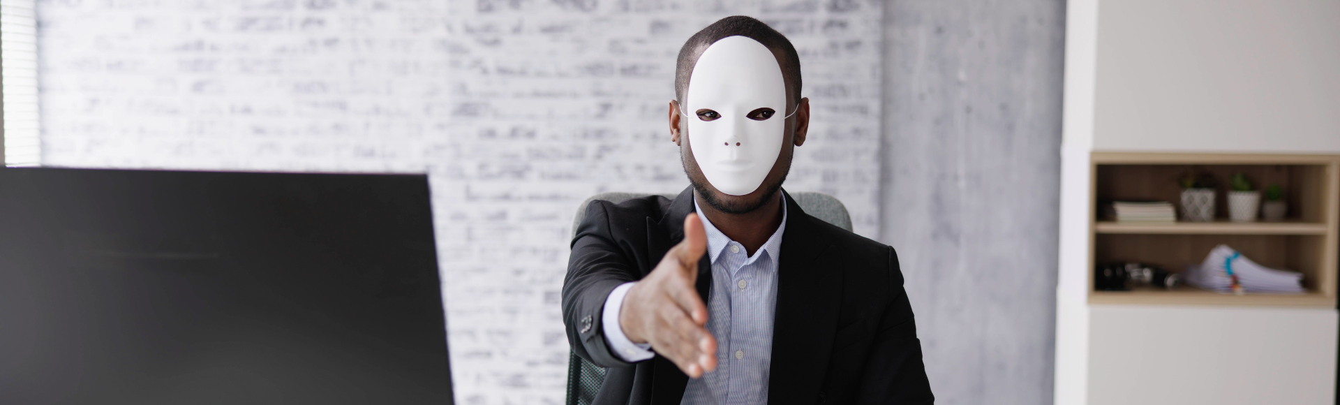 Masked individual extending a handshake, highlighting the importance of steps to avoid LinkedIn hiring scams.