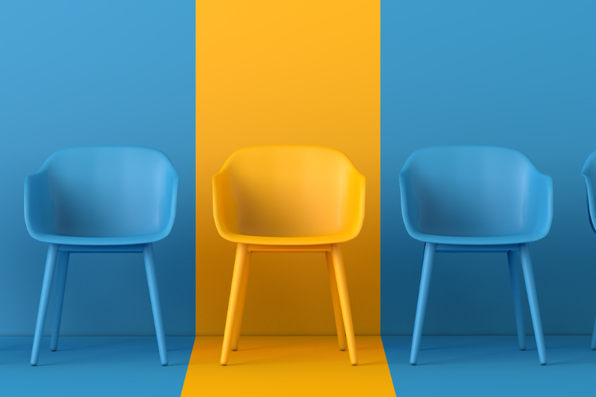 A yellow chair standing out among blue chairs, symbolizing uniqueness and diversity in talent sourcing.